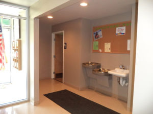 Doorway leading to Community Center Restrooms, with drinking fountains and bulletin board outside