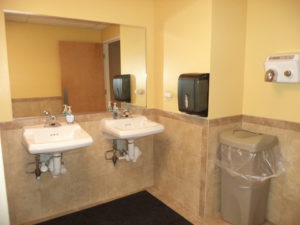 Community Center restroom with sinks, mirror, paper towel dispenser and automatic hand dryer