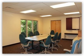 Conference room with long table, chairs and whiteboard on the wall