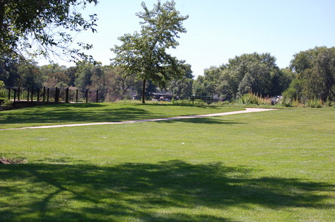 Manicured park lawn with trail and fence