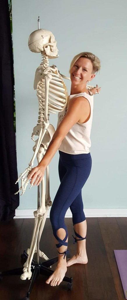 Yoga instructor Canella Mullins holds a skeleton