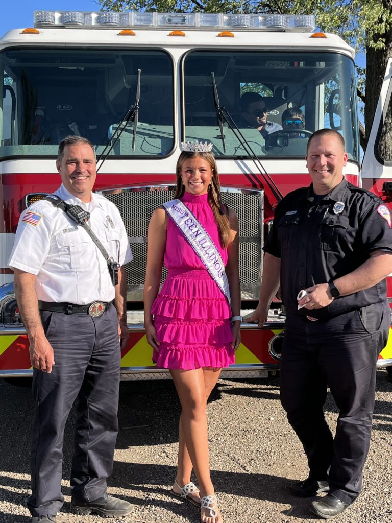 photo of Miss Teen Illinois International with 2 firemen at a Touch a Truck event