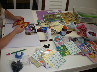 a person sitting at a table working on a scrapbook