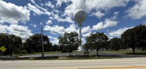 parking lot with water tower and trees in the background